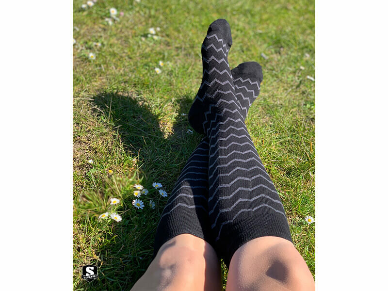 Model draagt compressiekousen electric black zwartgrijs gestreept