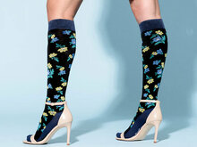 Model draagt compressiekousen print eastern delight zwart met gekleurde bloemen