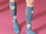 Compressiekousen licht blauw met witte bloemen roze achtergrond