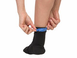 Model plaatst blauw coldpack aan de achterkant van zwarte cold therapy sock